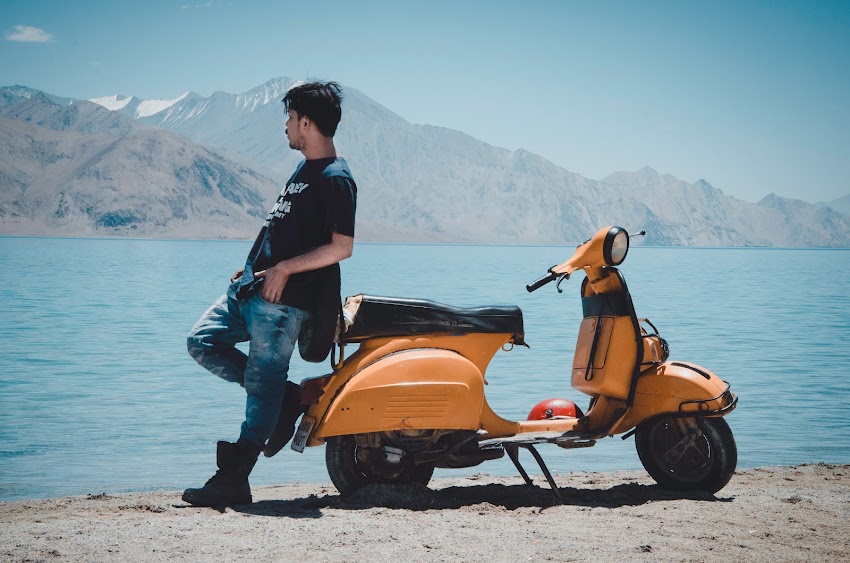 Photo of Man Leaning on Motorcycle Photo of Man Leaning on Motorcycle
