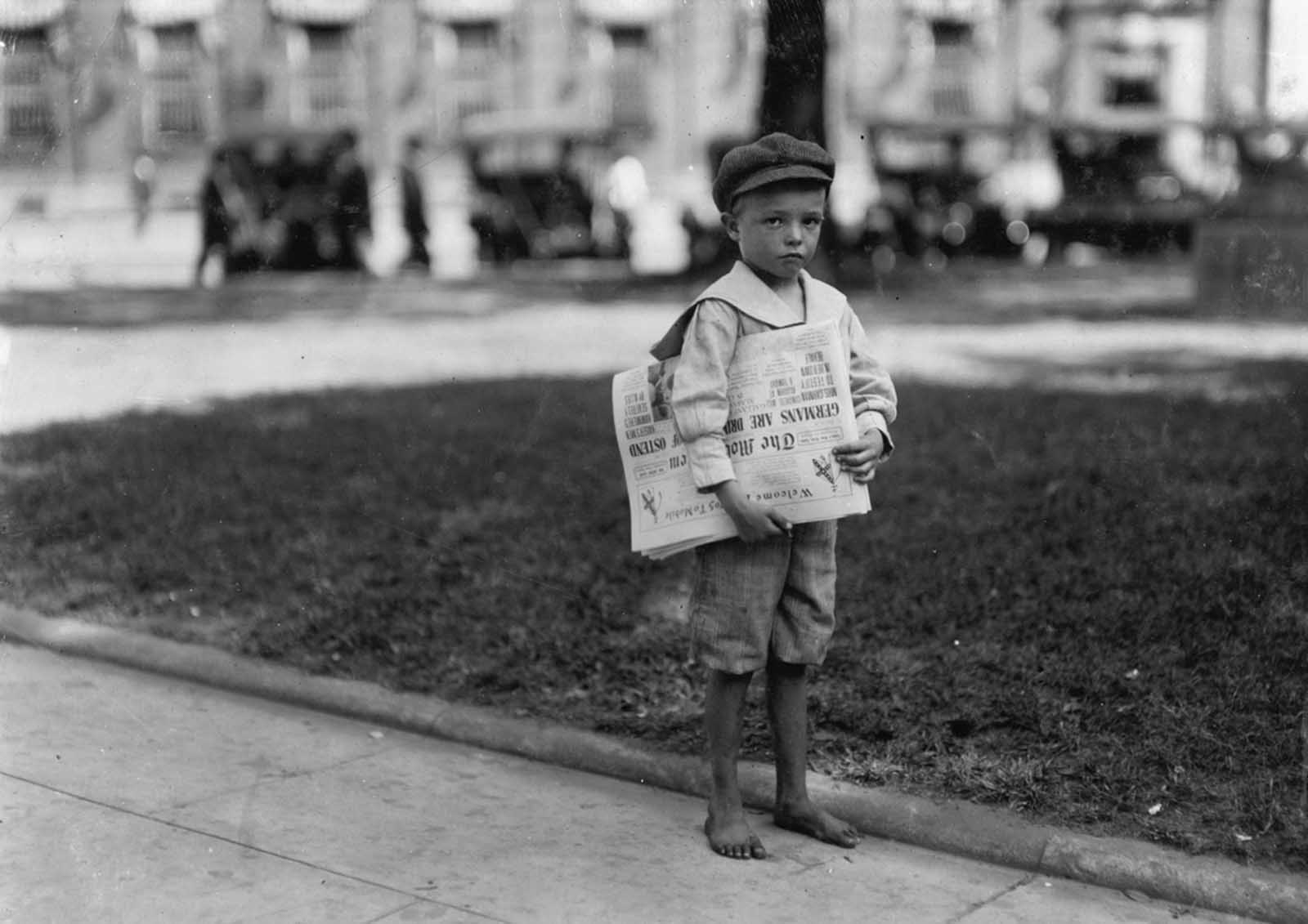 7-year-old year old Ferris, a small newsboy, or “newsie”, who did not know enough to make change. Photographed in Mobile, Alabama, in October of 1914. The newspapers he holds are copies of The Mobile Item, with the headline “Germans Are Driven Out Of Ostend,” describing the end of the Siege of Antwerp in World War I.