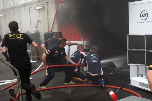 Racing%20team%20crews%20use%20a%20fire%20hose%20to%20try%20and%20extinguish%20a%20fire%20in%20the%20Williams%20garage.jpeg