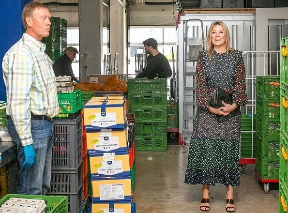 Queen Maxima wore a mixed ditsy floral tiered midi dress by Rixo. Gianvito Rossi shoes. She wore red earrings by Bodes and Bode