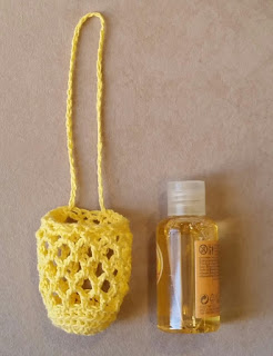 Left: a yellow mesh bag with a long drawstring loop; right: a 60 ml bottle of shower gel