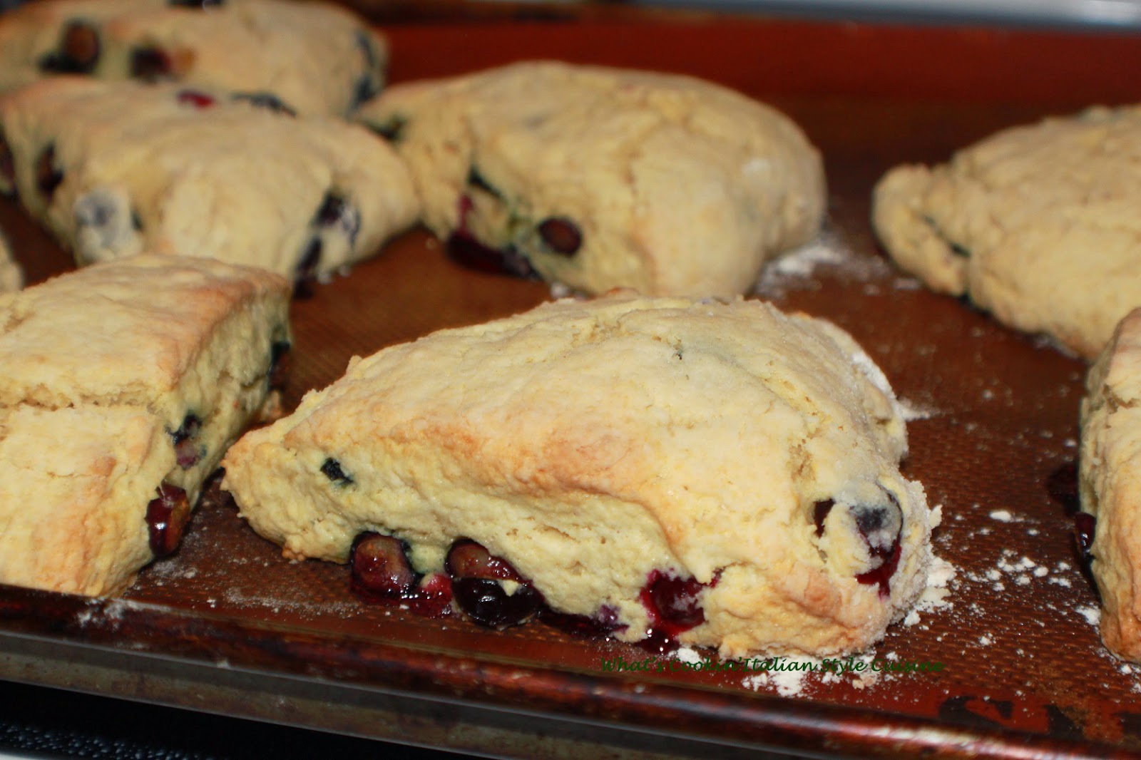 these are a delicious homemade buttery flavored baked biscuits called scones. These have blueberries in them with a drizzle of thin frosting over the top with slivered almonds. They are usually eaten at breakfast time in European pastry shops