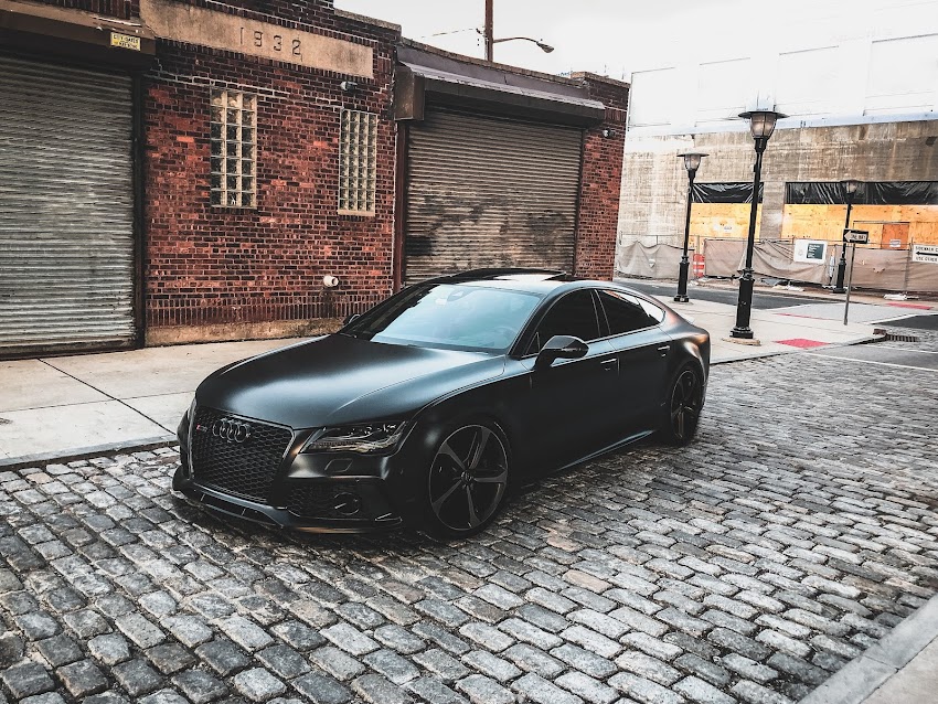 Black Audi A-series Parked Near Brown Brick House Black Audi A-series Parked Near Brown Brick House