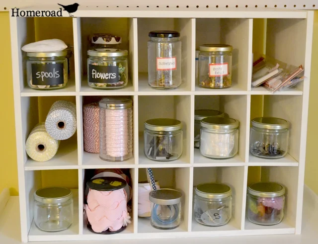 Multi space cubbie shelf with jars of crafts