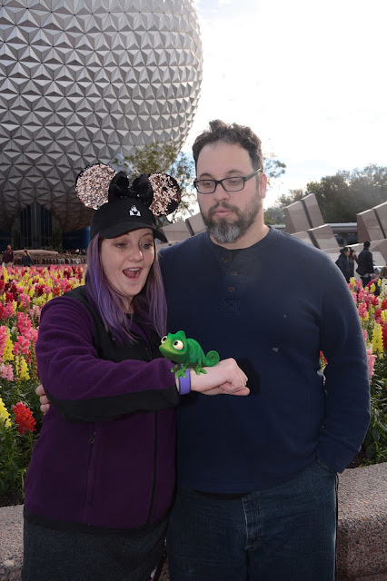 My husband and I with Pascal in front of Spaceship Earth at EPCOT FIVE || Buy Memory Maker So you can get your picture taken for free from PhotoPass photographers around the parks. They're stationed at photo-opp places like in front of the castle as well as with the characters. Any time any of them takes a picture of you with their professional cameras and photography skills, they scan your ticket (whether that's a card or Magic Band - more on that later) and your picture is then connected to your account. You can find all your PhotoPass pictures on your MDE app or online at the Disney Store here. Your ride photos are there too. The problem is, they have a watermark and you have to pay to download each photo you want. Unless you have Memory Maker. It's about $150 - $200 (depending on when and how you buy it) and you can download any and all photos on your account and do whatever you want with them. I especially recommend doing this if it's just the two of you going because you're going to want some pictures of the two of you together.