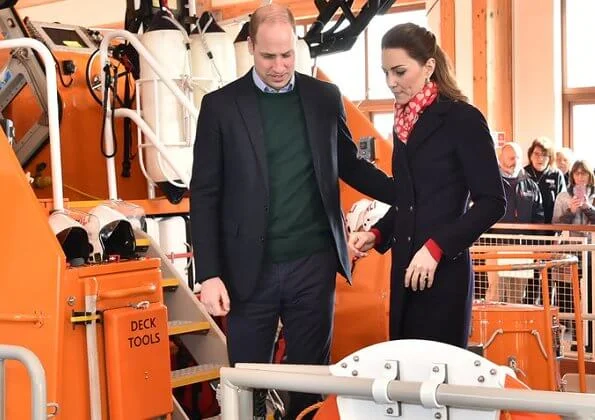 Kate Middleton wore a new navy coat by Hobbs London, and a new knitted puff-sleeve midi dress by Zara. Beulah London Kamala scarf