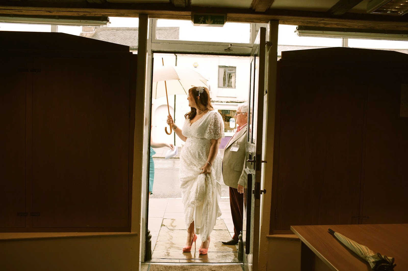 A Curvy Girl Stands in a doorway in her wedding dress
