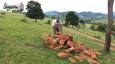 Bizzarri fazendo o que gosta, garimpando pedras na pedreira. Na foto escolhendo pedra para as construções com pedras, sendo um tipo de pedra moledo avermelhada tipo pedra chapa. Pedra para revestimento de pedra, parede de pedra, calçamento de pedra, escada de pedra, caminho de pedra no jardim e pedras para pisadeira de pedra no jardim.