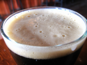 close up of head on a glass of dark beer