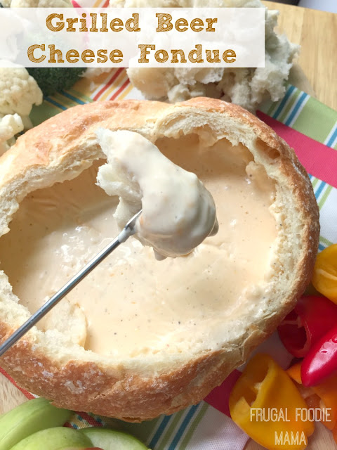A soft and crusty bread bowl is stuffed with a beer & garlic infused fondue cheese and then heated until melted and gooey over a grill or campfire in this Grilled Beer Cheese Fondue.