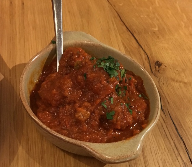 a dish of meat balls in tomato sauce