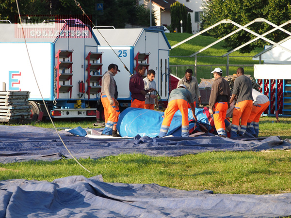 les ouvrier du Circus Knie  étendent sur l'herbe verte une des  grande toile qui formera la grande tente du cirque 