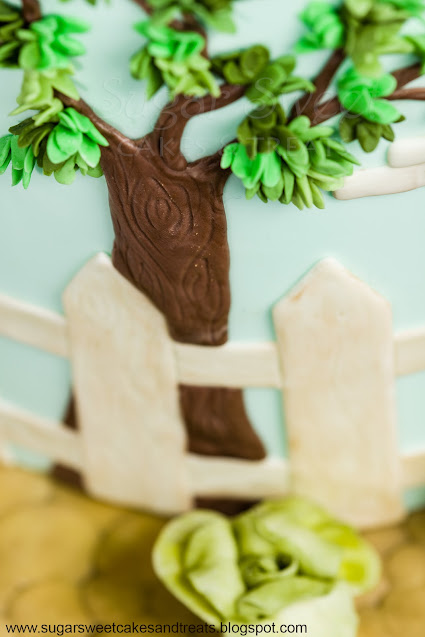 Closeup of fondant tree and leaves on the side of Beatrix Potter Baby Shower Cake.