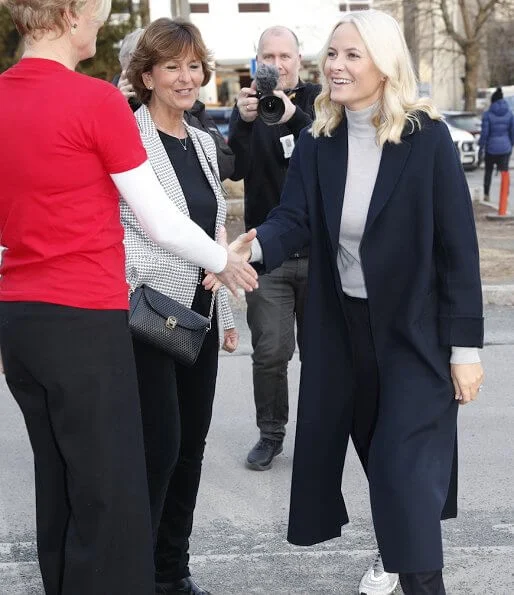 Crown Princess Mette-Marit visited the Fellesverket (Red Cross Youth Activity Centre) in Sandvika. navy wool coat, grey sweater