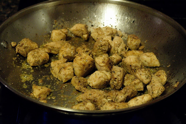 The diced chicken being browned in a skillet. 