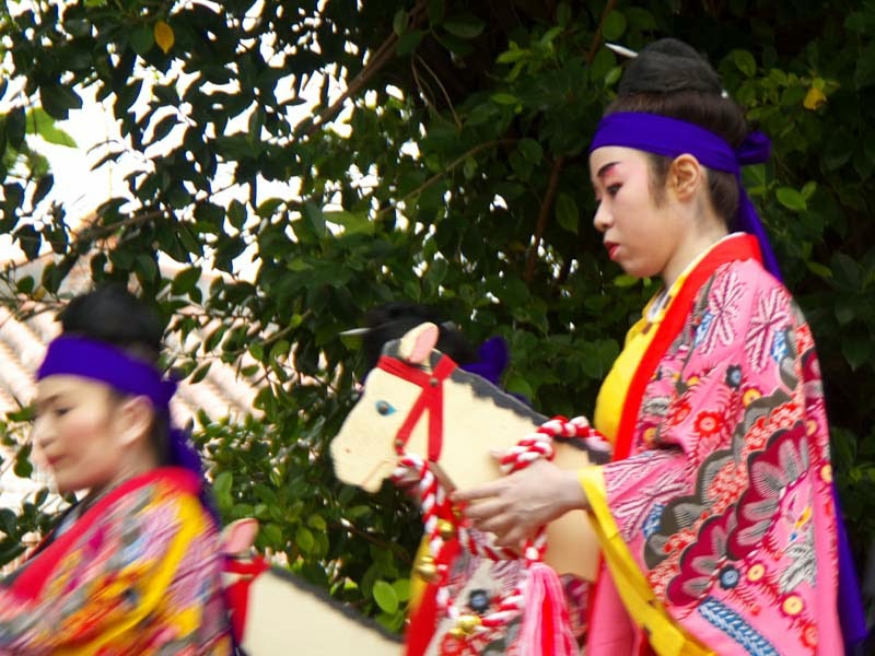 Kimono clad women dance riding wooden horses