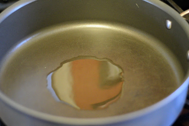 A pan on the stove with oil in it. 