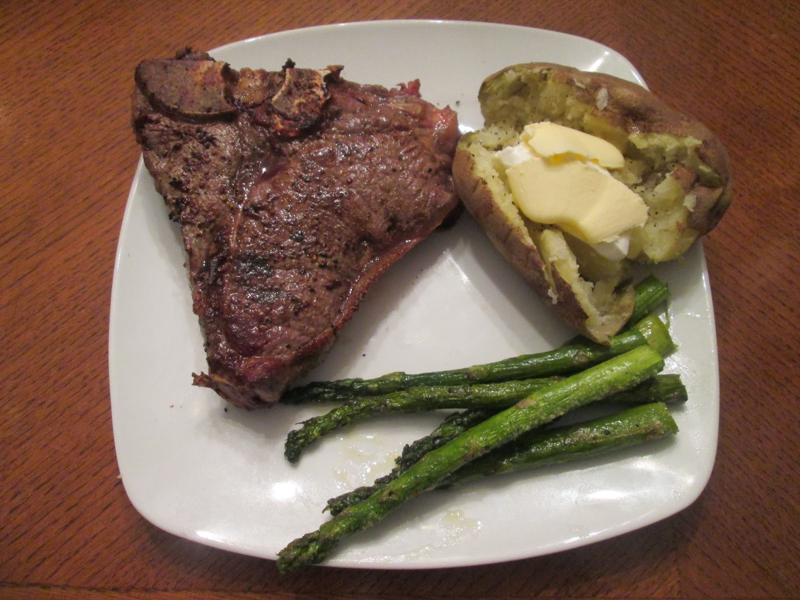 Premium Photo Steak with bone and potato baked in oven in a roasting