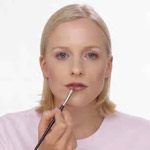a woman applying lip gloss