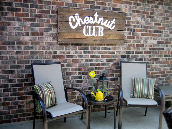 Look at how great this DIY pallet sign looks mounted on the backyard wall!