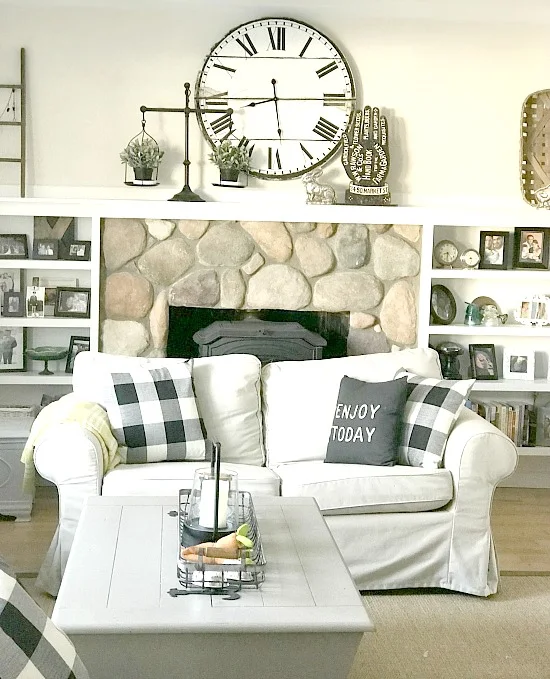 Neutral farmhouse living room with love seat and mantel with clock