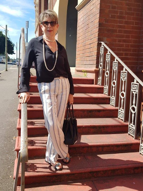 White striped pants/black blouse and pearls