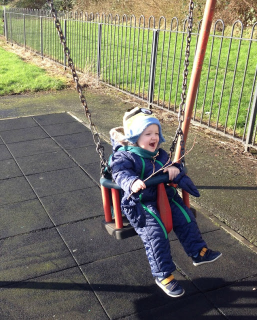 toddler on a swing holding a stick