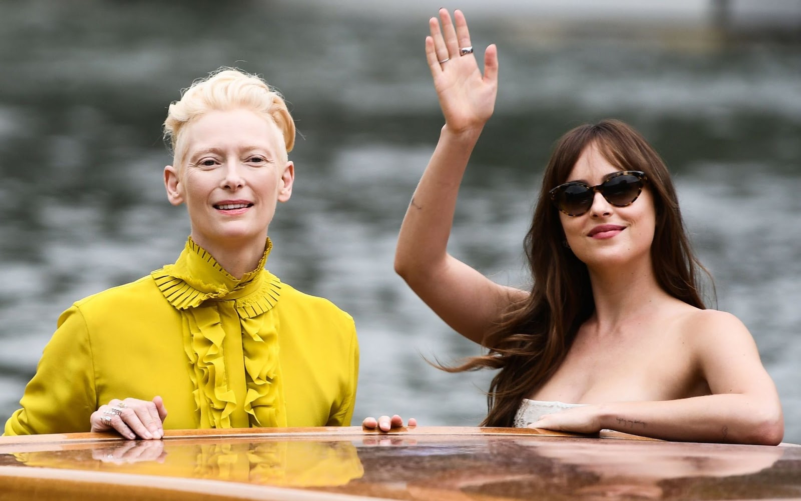 Actresses Dakota Johnson (R) and Tilda Swinton arrive by boat at the Excels...