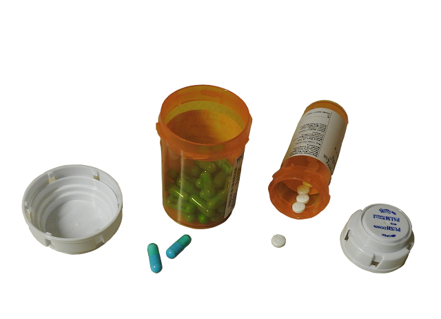 Bottles of medicine with caps off.