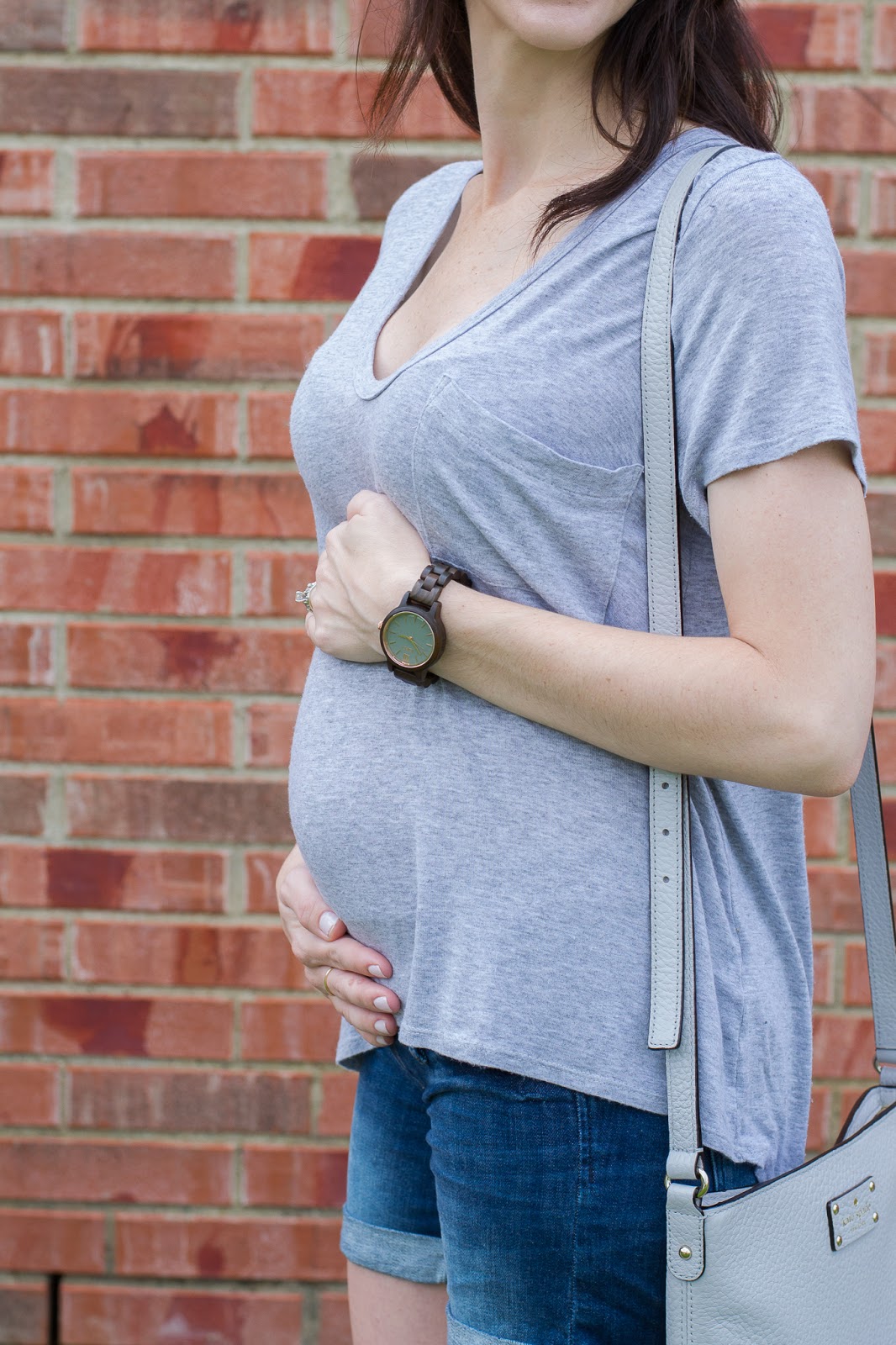 Summer baby bump in a basic tee and wood watch 