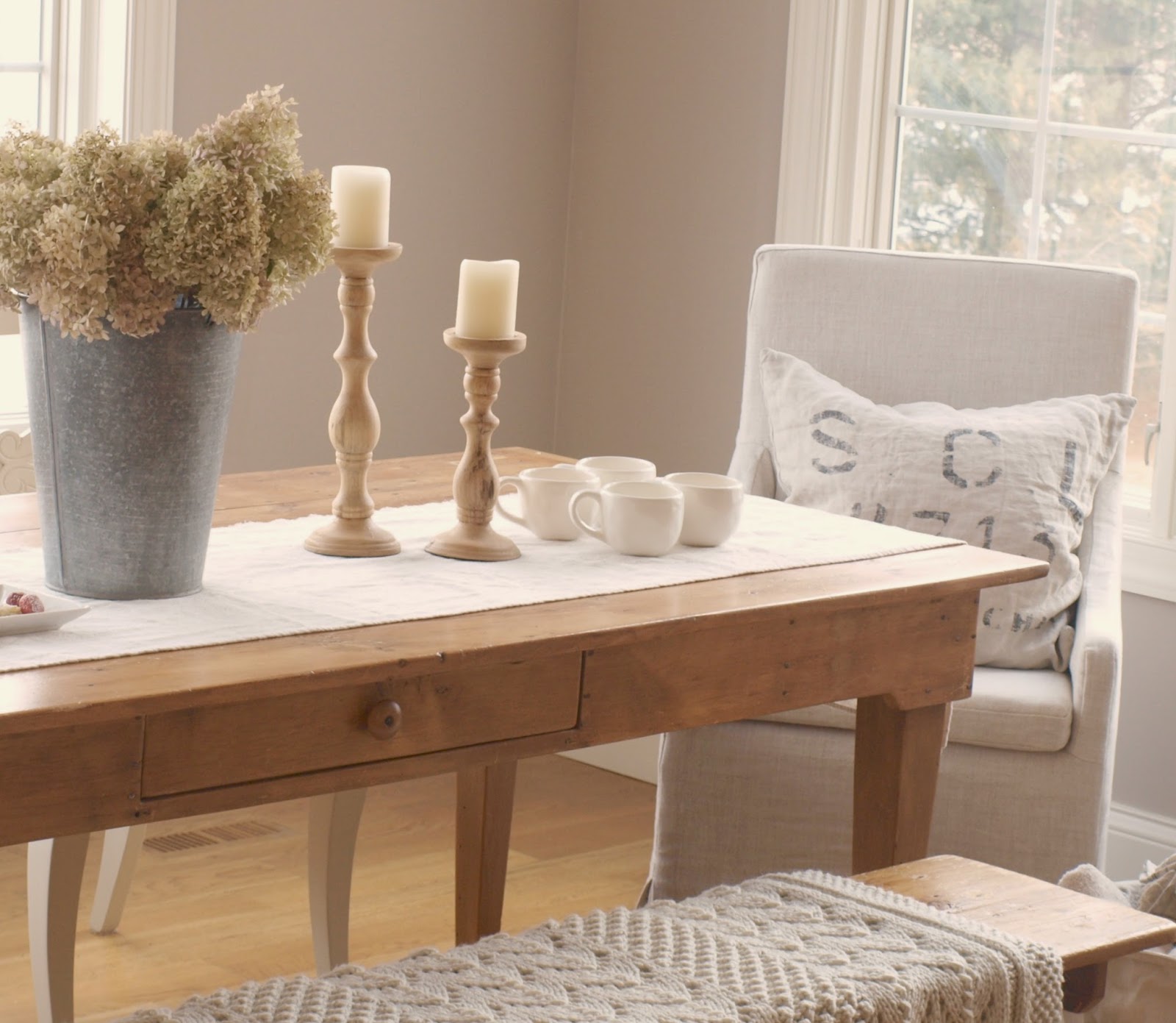 European farmhouse style dining room with farm table and Belgian linen arm chairs. Design by Hello Lovely Studio. #diningroom #belgianlinen #europeanfarmhouse #frenchfarmhouse #benjaminmooreashleygray