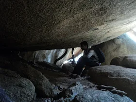 A narrow crevasse or hole in the cave floor that requires squeezing through