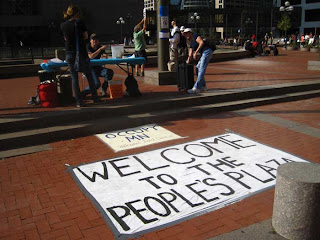 Occupy Minnesota welcome table with large sign that says welcome to the people's plaza