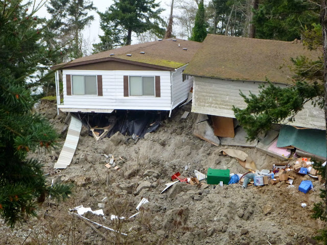 House damaged by March 27, 2013 Whidbey Island landslide. Photo by Washington State DNR used under CC BY-NC-ND 2.0, accessed from https://flic.kr/p/e6HtAk