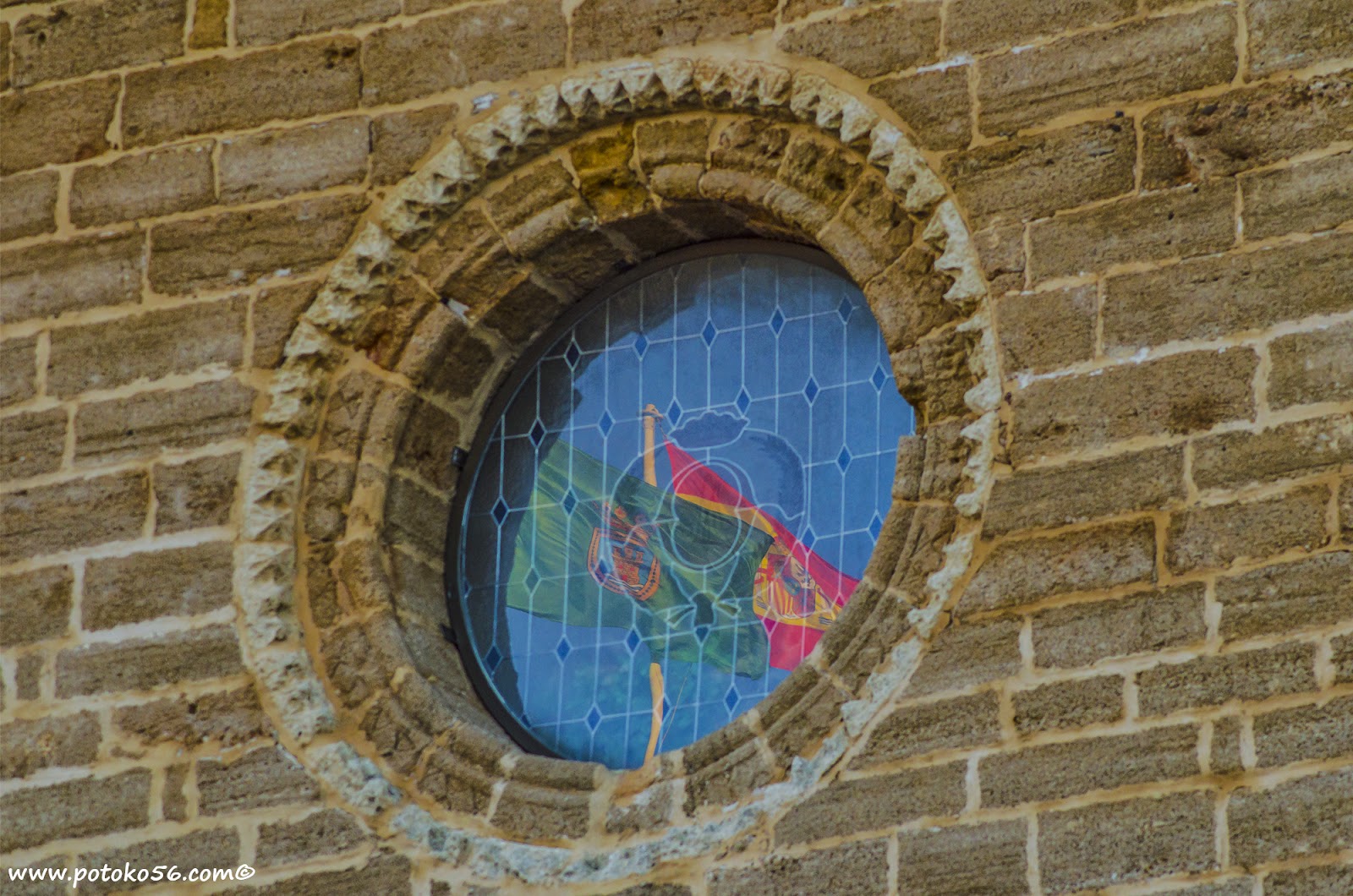 Reflejos de las banderas en la vidriera de la Parroquia de La O en Rota