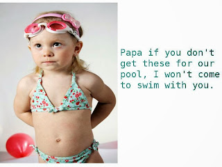 Picture of a toddler in he bathing suite, goggles and a head band, standing beside a ball and with her hand behind her back saying "Pappa, if you don't get these for me I won't go to the pool with you". This article is about 5 must-have accessories for your swimming pool