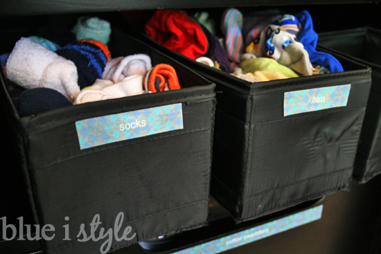 baskets on armoire shelf for baby clothes socks and supplies