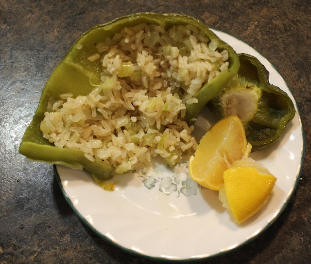cooked stuffed green peppers and lemon on plate