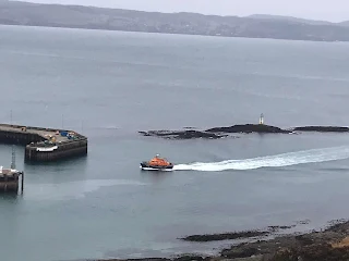 rnli mallaig lifeboat coming in to rural harbour