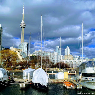 photo of Toronto waterfront showing boats, CN Tower and the cloudy sky