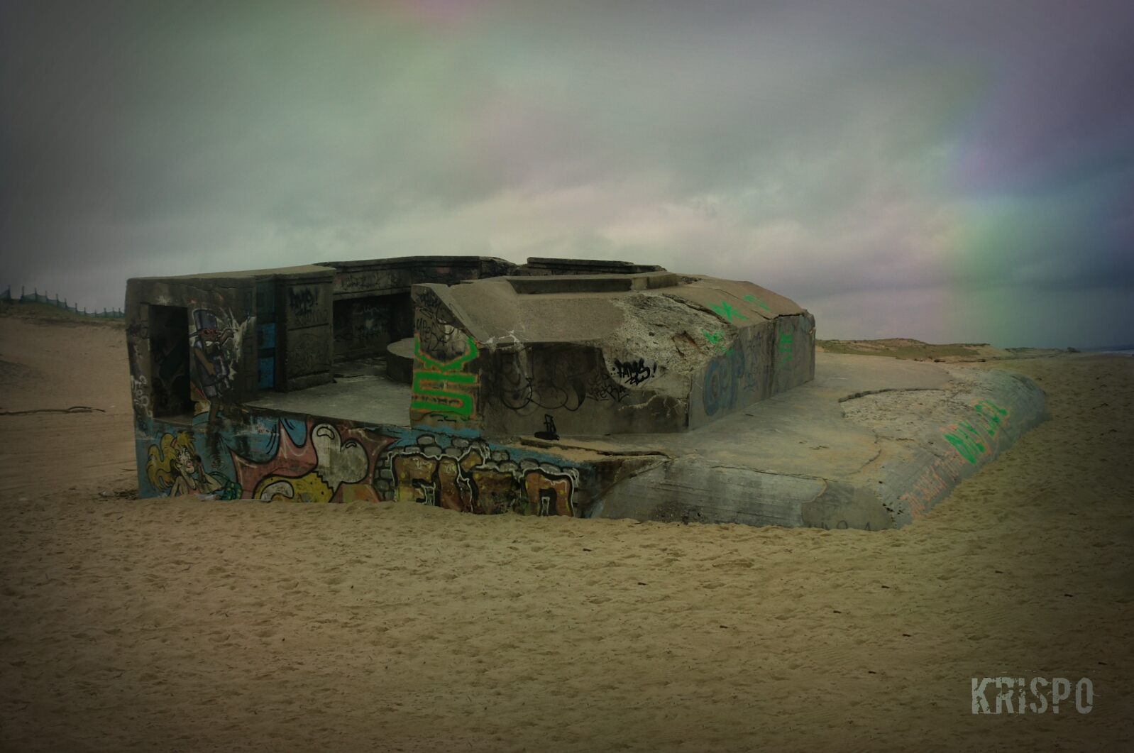 bunker semienterrado pintado con graffitis en playa de las landas