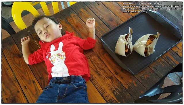 gambar kanak-kanak perempuan memakai baju kanak-kanak merah, seluar denim kanak-kanak biru tidur atas meja makan di Nasi Berlauk Ayam Cincang AJ.