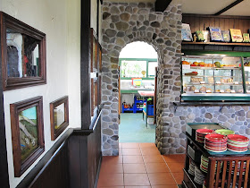 Inside of Mr Badger's cafe at Tawhiti Museum, with a wall of one-twelfth-scale miniature scenes set into the left wall.