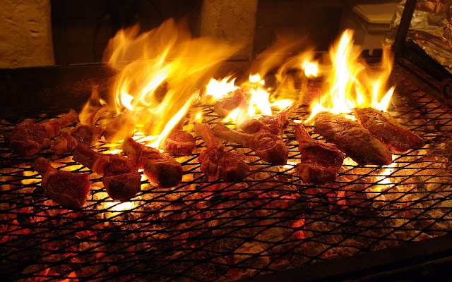 Vlees op de barbecue met hoge vlammen