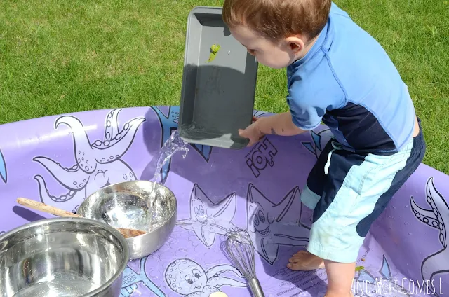 Preschooler pouring water in a kiddie pool as part of a music science experiment for kids