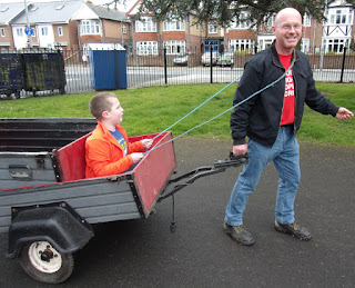 man pulls car trailer with passenger