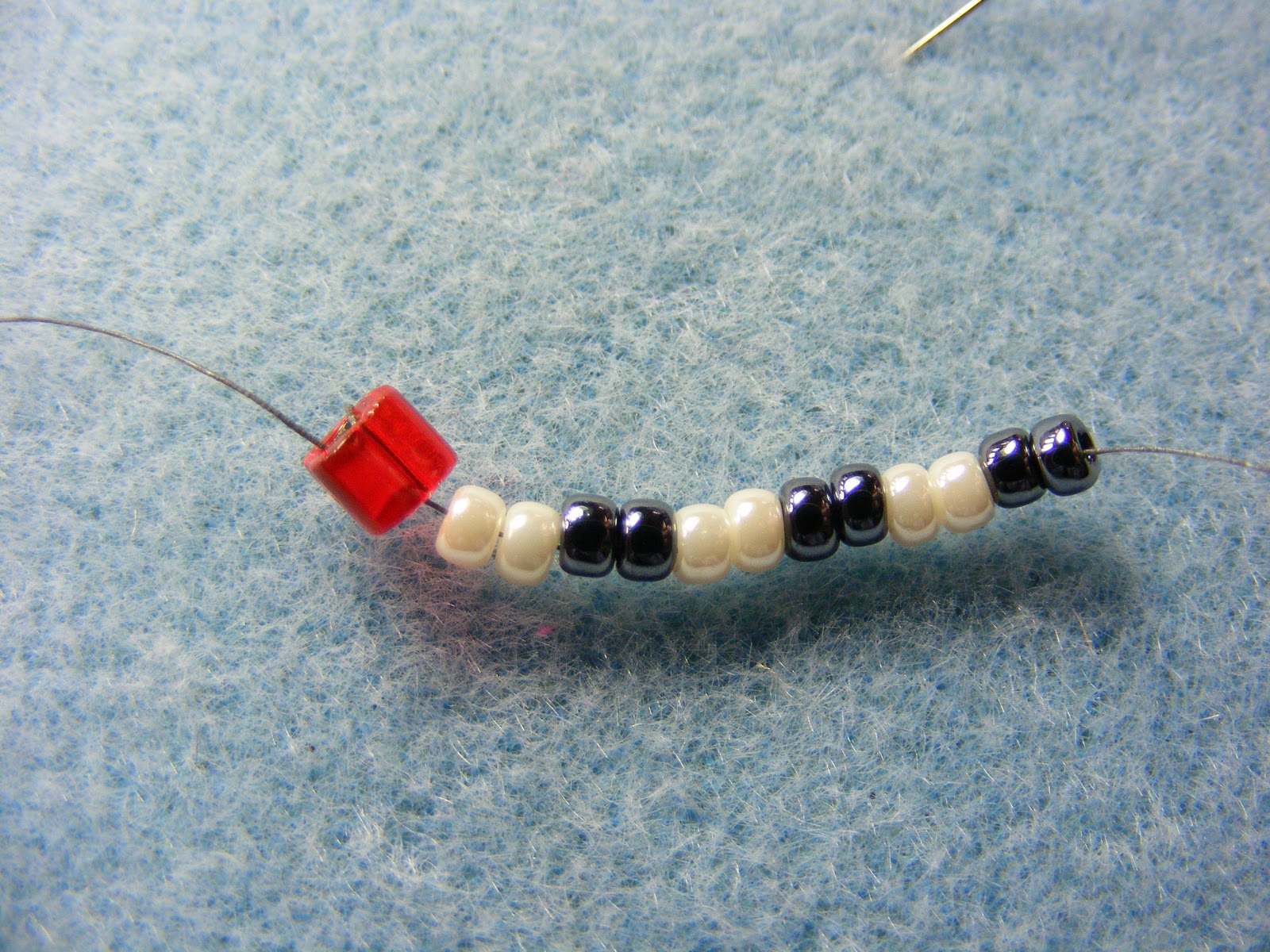 глаза для игрушек. две маленькие закрепленные бусинки. две маленькие закрепленные бусинки. две маленькие закрепленные бусинки. как обмотать бусину вокруг леской.