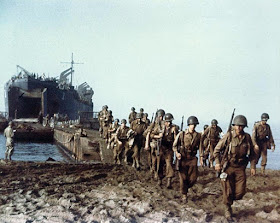 American troops disembark from a US Navy tank ship across a causeway set up by the beach at Palermo