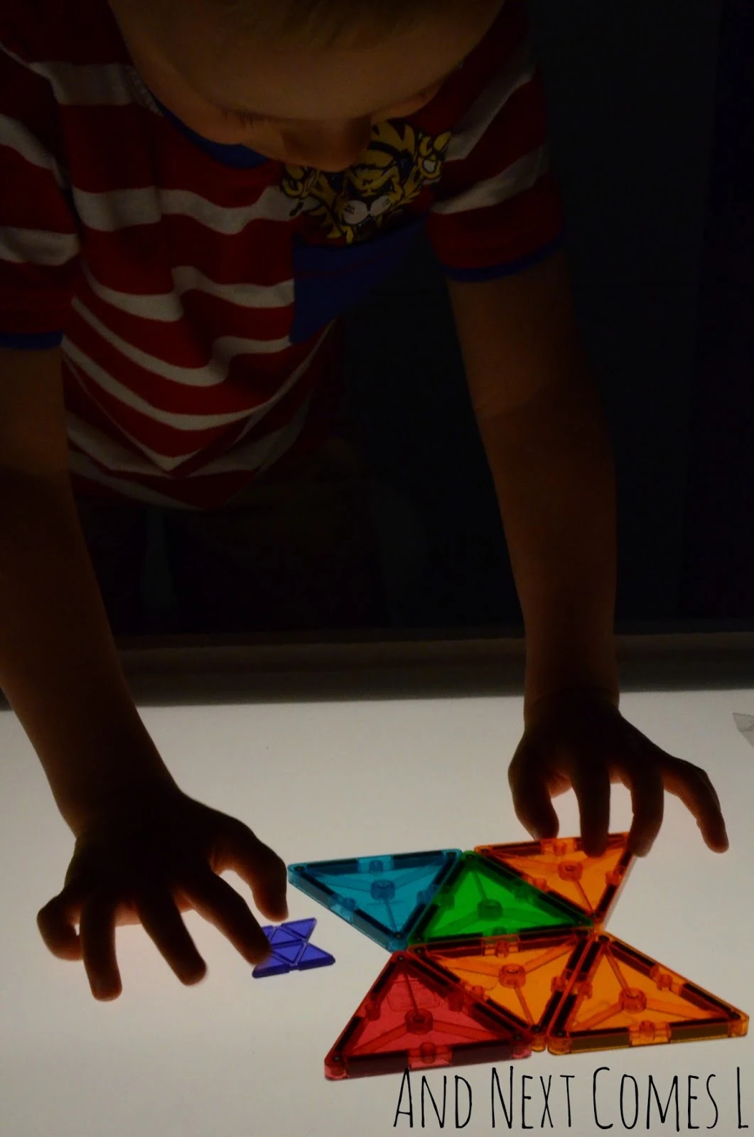 Using Magna-Tiles to recreate shapes on the light table from And Next Comes L
