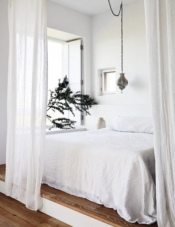 Cozy bed behind sheer curtains